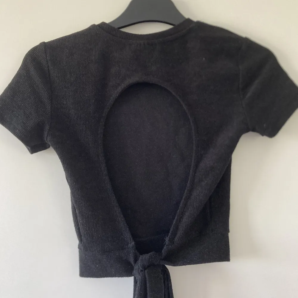 supersnygg svart t-shirt med öppen rygg från Gina Tricot.😍 Materialet är lite ribbat och ifall snöret känns lite långt är det lätt att sy det kortare.💕. T-shirts.