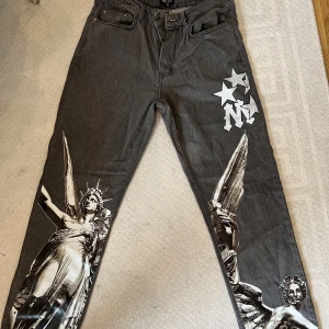 Gråa baggyjeans med tryck - Snygga gråa baggyjeans med tryck av olika slag, köpte från boohooman i storlek 32, vilket motsvarar ca L för att få en mer baggylook. Kommer dock inte till användning och därför säljer jag de. 
