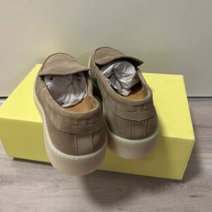 Vico Loafer Sneaker är en modern version av en klassisk loafer och är den perfekta vårskon. Den har en ovandel i mjuk mocka med en sneakerliknande gummisula, så att dina fötter kan ha det bekvämt hela dagen.