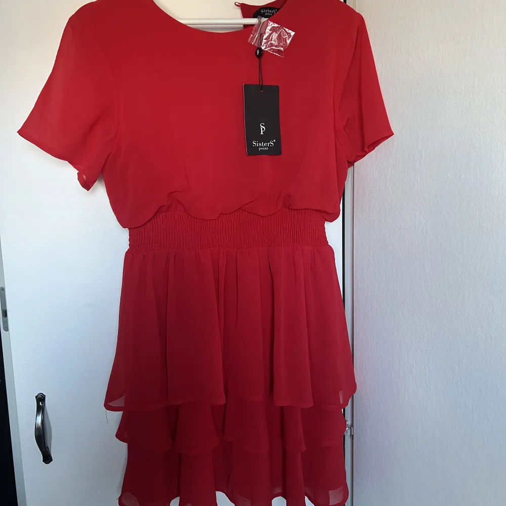 En jättefin röd volangklänning som tyvärr aldrig blivit använd, lappar sitter kvar. . Klänningar.