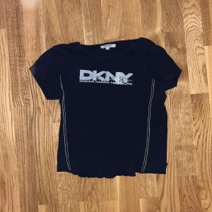 DKNY t-shirt - T-shirt från DKNY. Oklar storlek men lite croppad, troligen XS-S
