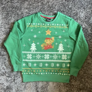 Grön ”Super Mario” Jul Crewneck - Grön Mario Jul Crewneck. Storlek S. Knappt använd, inga märken/hål/smuts och kvaliten är väldigt bra. Kunden betalar frakten 😚.