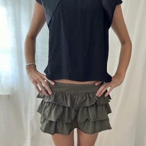 Mörkgrön minikjol med volanger - Så fin minikjol med volanger, resår högst upp (har vikt med den på bilden!)