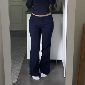 Marinblå lågmidjade kostymbyxor  - Lågmidjade kostymbyxor i storlek 34 från Åhléns. Klippt av längst ner då de va för långa men passar någon som är ca 160cm. 