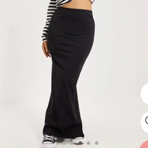 svart långkjol Nelly - Denna svarta långkjolen sitter väldigt fin och är i bra längd för mig som är 1,74 och jag använder den lågmisjad. 