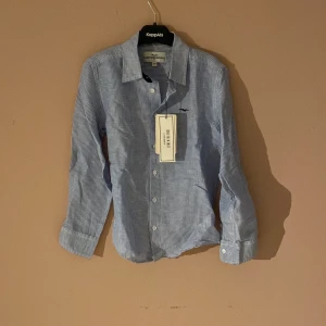 Oanvänd skjorta i Linen blendmaterial. Stl.140 - Så fin oanvänd sommarskjorta!  Blå och vitrandig i stl.140.  Perfekt till midsommar 💙