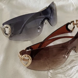 Y2k solglasögon! - Två st supersnygga solbrillor i y2k stil. Köpte dem (helt oanvända) på Plick men säljer då de var för stora på mig. Bilderna är lånade av säljaren. Skriv om du har frågor eller vill ha fler bilder! Köparen står för frakt, kan även mötas i Stockholm