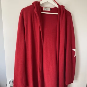 Röd kofta - Superfin kofta med stjärnor på armbågarna. Sparsamt använd! Har luva och är väldigt skön i materialet. 