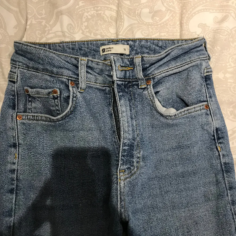 Ljusblå jeans med split från Ginatricot i storlek 36, använt fåtal gånger. Midjemått rakt över 35 cm, innerbenslängd 84. . Jeans & Byxor.