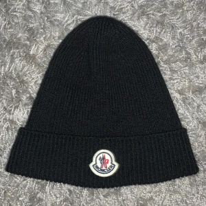 Moncler Mössa - En Moncler beretto mössa, bra skick. En perfekt mössa inför vintern. Nypris ligger på 3000kr, ind tag är ej kvar då den var i vägen vid användning. Orderbekräftelse har jag, bara att höra av sig om det är något🙌🏻💯