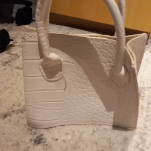 Väska - En vit väska från shein. Gullig o fin att ha till ex fest.