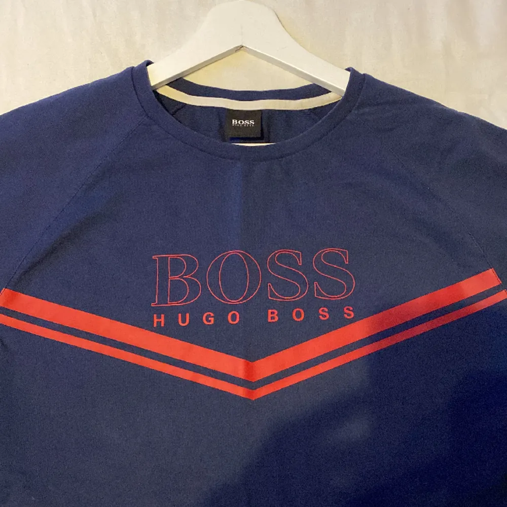 Blå Hugo boss tröja med röd text andvänd ett fåtal gånger . Tröjor & Koftor.