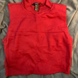 Topp med polo krage - Topp i vinröd färg, mjuk och stretchig tyg. 