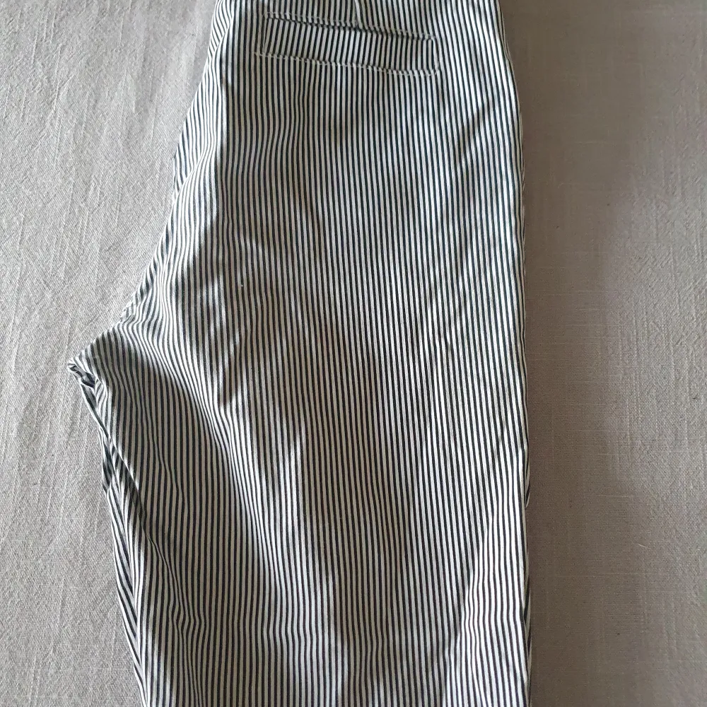 Svart/vita randiga byxor i stretch med snöre som bälte. Endast använda 2 ggr så i i fint skick.. Jeans & Byxor.