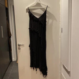 Svart klänning - Svart långklänning med frills på från H&M. Använd endast en gång