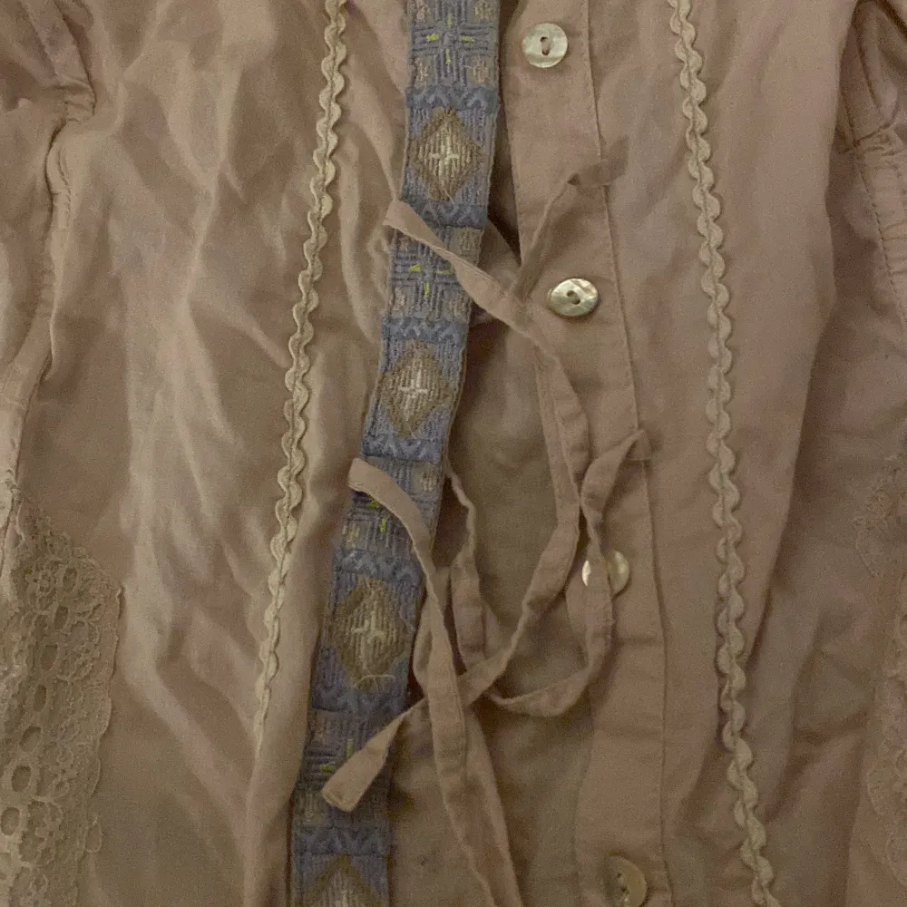 Väldigt fin blus i gammelrosa med inslag av lila och blått i form av brodering. . Blusar.