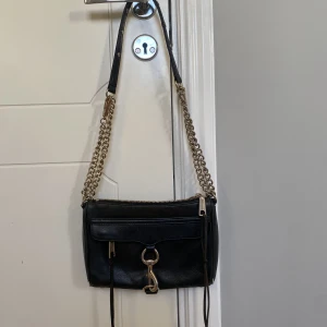 Rebecca minkoff - En Rebecca minkoff väska, svart med guldiga detaljer. Väskan är andvänd men inget överdrivet gulfärgen har släppt lite på spännnena på banet bara. Funkar perfekt som party väska!😍✨