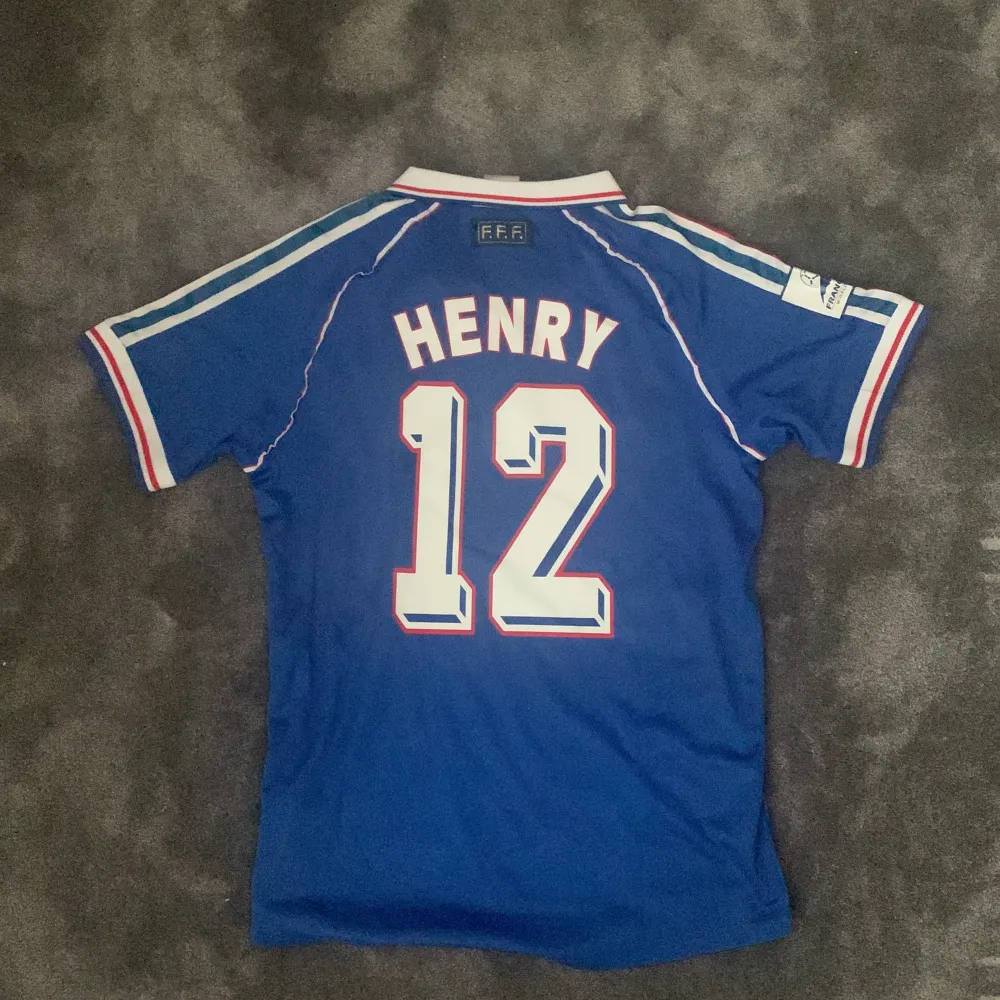 En fransk fotbollströja från VM 1998 med Henry på ryggen.. T-shirts.