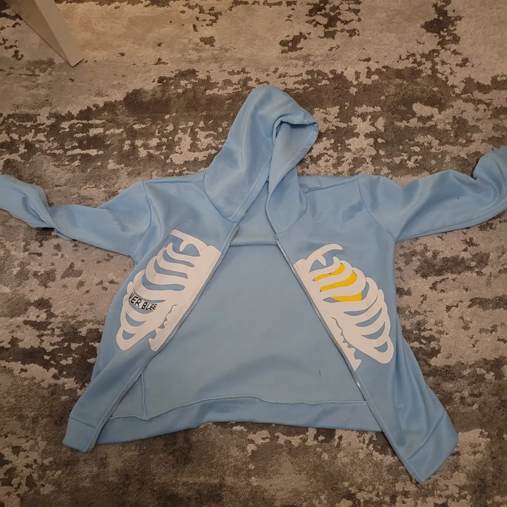 Säljer blå skelett zip up hoodie. 110kr Priset är diskuterbart vid snabb affär Storlek M  Skriv om ni undrar något. Tröjor & Koftor.