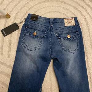 Supersnygga midrise bootcut jeans från True Religion. Jeansen är i storlek 27 och är helt oanvända med lapparna kvar. Midjemåttet är 36x2cm och är väldigt stretchiga, samt innerbenslängden är 79cm. Köptes för $159 vilket motsvarar ca 1650kr💓