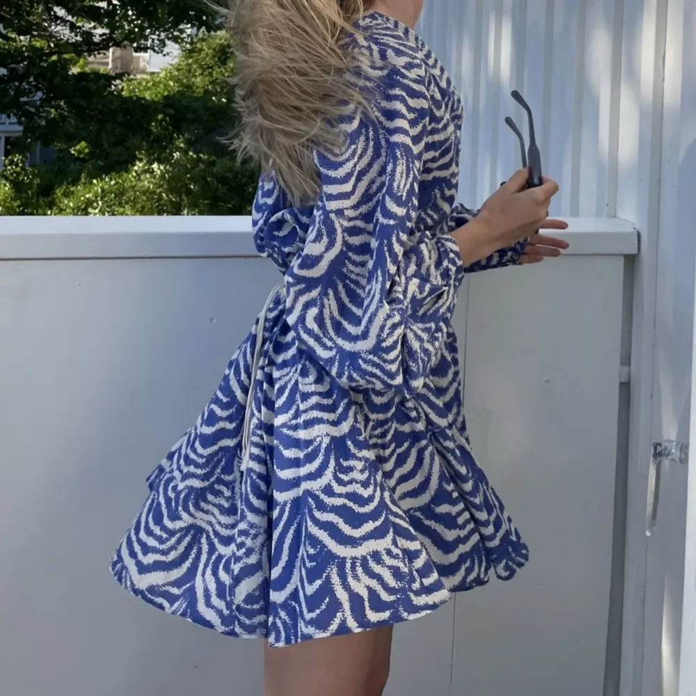 Blå mönstrad klänning från H&M med band runt midjan!🙌🏽 Använd 2ggr 🤍 Nypris 399kr🫰🏽💙. Klänningar.