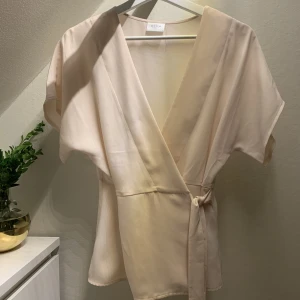 Omlottblus - Ljusrosa omlottblus från Vila. Använd en gång. Storleken är 34, men den är lite stor i storlek. 