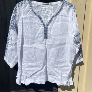 Vit sommarblus - Fin somrig blus med mörkblå detaljer. Fint skick.