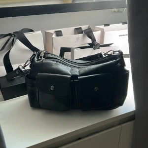 Svart handväska  - Svart handväska i fint skick, många bra fack utanpå och inuti. Finns även ett längre band till väskan man får med.💕