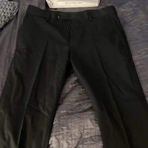 Svarta lågmidjade Kostymbyxor  - Ett par svarta kostymbyxor som är i ett väldigt bra skick och är bara använda en eller två gånger. Produkten har inga skador på alls. 