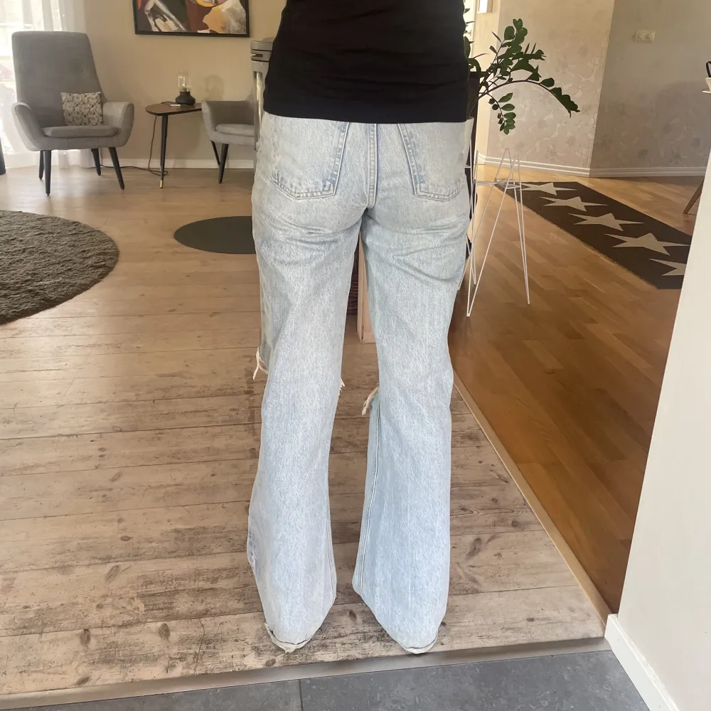 Säljer nu dessa högmidjade bootcut jeans från zara med hål i båda knäna. De har används mycket så de är lite slitna längst ner. . Jeans & Byxor.