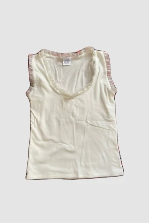 Vit topp med fina detaljer  - jag har sytt in den men det går att sprätta upp