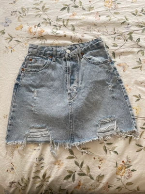 Jeanskjol - Snygg jeanskjol från spanska märket stradivarius. Ganska sparsamt använd så i bra skick! Pris är exklusive frakt