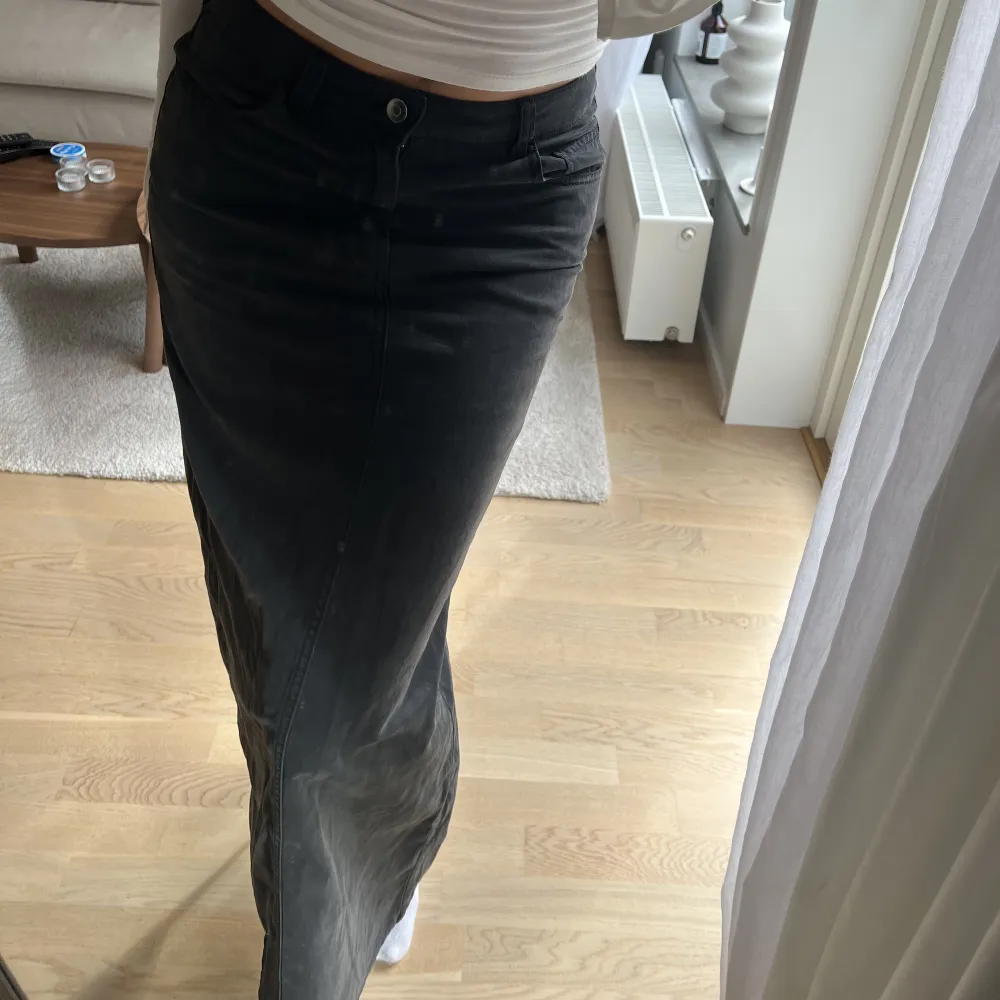 Kjol i jeans material. Lång och har en slit där bak. Svart/grå tvätt med fickor jag är 172cm. Kjolar.