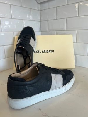 Axel Arigato skor - Ett par Axel Arigato skor som inte säljs längre! Sjukt snygga och fräscha i skicket 9/10! Finns som sagt inte längre att köpa men nypris idag skulle ligga runt 3000😊