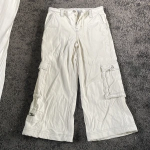 Vita cargo byxor  - Shit snygga cargo byxor, helt oanvända. Dom har lagts up lite i benen så imr du är precis under storlek 32 så e dom perfekta för dig. 