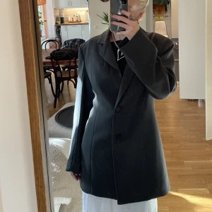 Blazer - Så snygg blazer i nyskick 🖤den är en mörk grå. Jag är normalt en S och blazern är en M för en oversized fit. Den sitter lite mer feminint då den er innsydd i midjan. Köpte ny för 800kr. Säljer för halva priset.