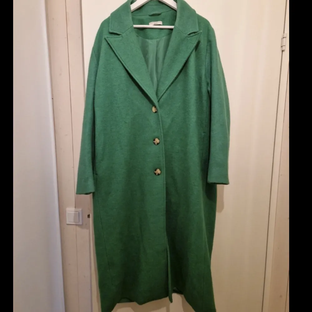 Fin grön kappa, sitter fint på och är lång. Älskar denna men dessvärre för stor, skön och passar de mests outfitsen. Inte alls mycket använd. . Jackor.