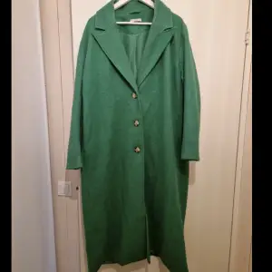 Fin grön kappa, sitter fint på och är lång. Älskar denna men dessvärre för stor, skön och passar de mests outfitsen. Inte alls mycket använd. 