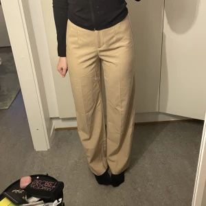 Beiga mjuka kostymbyxor  - Sköna, mjuka kostymbyxor från Bershka. Använt sparsamt. Längden i benen är 80cm. Jag är 174 och har storlek S vanligtvis, fina😍