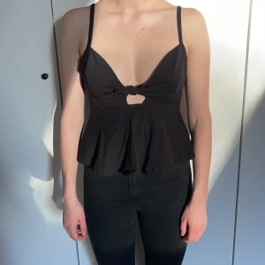 Svart linne med rosett  - Svart volang linne med rosett. Väldigt bra skick! Storlek S. Modellen bär vanligtvis storlek S och är 168cm lång. 