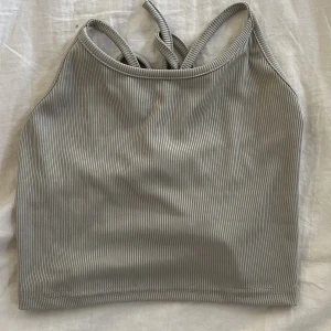 Topp med öppen rygg - Jättegullig grå sommartopp med öppen rygg och band. 