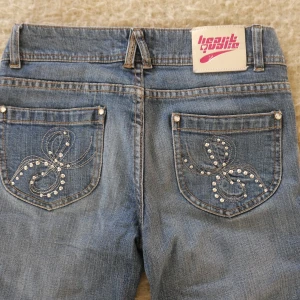Lågmidjade jeans med rhinestones  - Så otroligt snygga jeans från heart quake med balla detaljer på fickorna. Säljer då de tyvärr inte kommer till användning. De är i bra skick och har endast använt dem ett fåtal gånger. Midjemått: 79 cm 