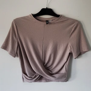 Ljusrosa/beige crop-top - En ljusrosa/beige kroppad t-shirt. Använt ett fåtal gånger, så gott som nyskick. 