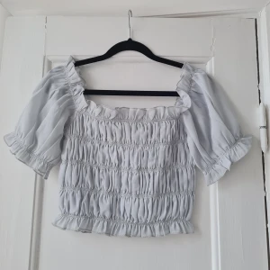 Blus / topp - Mintgrön/ljusblå blus med massa resårer och puffaktiga ärmar. Aldrig använd, endast provad. Från Nelly