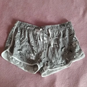 Shorts i strl S/M - Ett par gråa shorts med grå/vita blommor på. Bra att sova i eller bara att ta med till stranden över badkläderna 