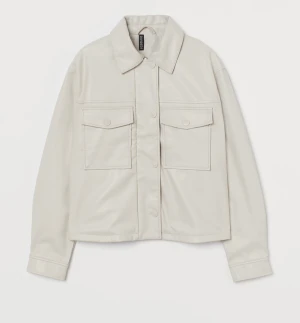 Skinnjacka - Croppad skinnjacka i fuskläder från H&M i storlek S. Den är creme färgad. Gratis frakt via tise 