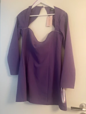 Lila klänning  - Säljer denna snygga klänning från prettylittlething med strass vid halsen. Aldrig använd helt ny med alla lappar kvar. Storlek 40