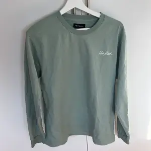 En långärmad tröja ifrån märktet New Black i storlek M. Den är i bra skick och säljs för att den inte kommer till användning. Färgen är imot de gröna hållet fast lite mildare grönt. Hoppas ni ser bra på bilden.