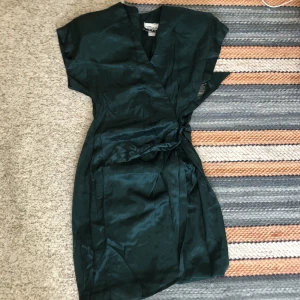 Grön sidenklänning  - Köpte vintage, troligen 80-tal då den har axelvaddar (: superfint skick och material! Får tyvärr inte använding av den bara(: passar nog s-m men kan dras åt rejält i midjan!