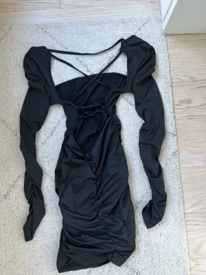 Svart klänning - Säljer denna supersnygga svarta klänning. Säljer på grund av att jag ej har anvöndning av den. Klänningen är i storlek xs och den har en öppen rygg med snörning.